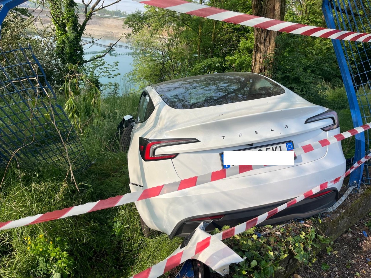 Una Tesla nuova distrugge la recinzione e si ferma sopra un laghetto
